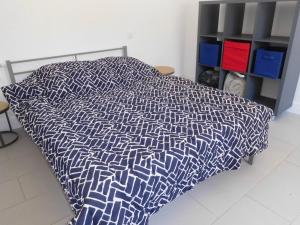 uma cama com uma colcha azul e branca num quarto em LES BRUYERES em Léon