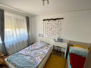 ein kleines Schlafzimmer mit einem Bett und einem Schreibtisch in der Unterkunft “Home sweet home” in Sîntandrei