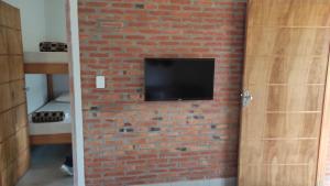 een stenen muur met een tv aan een stenen muur bij La Hacienda in Atyrá