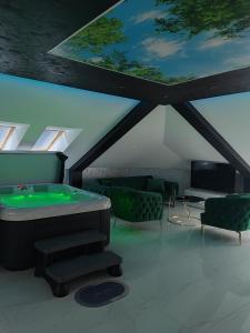 um quarto com uma mesa de bilhar e cadeiras verdes em Hedonic Wellness Apartmani em Niš