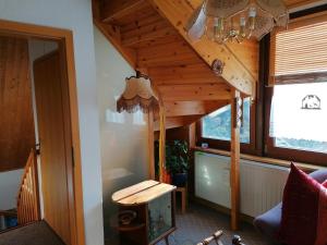 a living room with a wooden ceiling and a table at Ferien im Haus am Waldrand in Freital