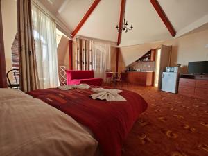 um quarto com uma cama grande e um cobertor vermelho em Villa Lira em Hévíz
