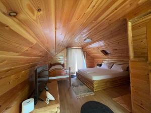 1 dormitorio con 1 cama en una cabaña de madera en Guesthouse Pogradec, en Pogradec