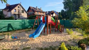 a playground with a slide in a yard at GUNER Apartament Bełchatów in Bełchatów