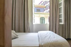 łóżko w pokoju z dużym oknem w obiekcie Oporto Sweet Downtown 3 w Porto