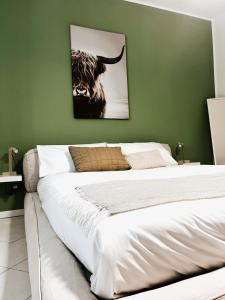 1 cama en un dormitorio con una pared verde en Daisy Homes #2 en Monza