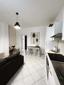 cocina y sala de estar con sofá y mesa en Daisy Homes #2 en Monza