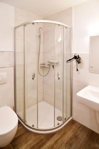 y baño con ducha, aseo y lavamanos. en Haus-am-Kliff-App-07, en Heringsdorf