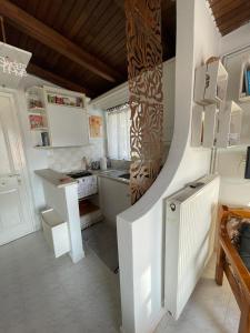a kitchen with white cabinets and a spiral staircase at Cozy Loft - Best view of the city in Lamía