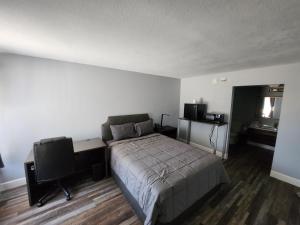 a bedroom with a bed and a desk and a television at Heritage Place Hotel in Iuka