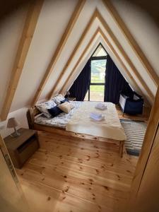 a bedroom with a bed in a attic with a window at Prima Vista in Žabljak