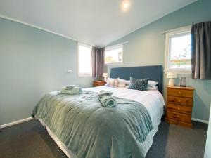 a bedroom with a bed with towels on it at Kauri Villas in Parua Bay