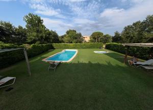 a backyard with a swimming pool and a grass yard at Mas Ombravella in Mieras