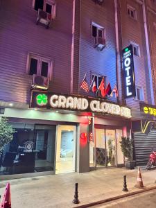 a grand cloverleaf sign on the side of a building at Grand Clover Otel in Seyhan