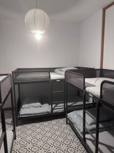 Pokój z 3 łóżkami piętrowymi i lampką w obiekcie One World Hostel Gdansk w Gdańsku