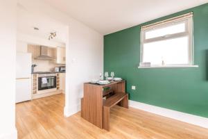 a kitchen with green walls and a wooden table at Centralised Horton Place with FREE PARKING by Prescott Apartments in Bristol