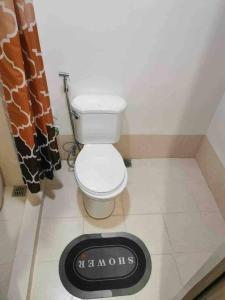 uma casa de banho com WC e relógio no chão em JustAnn Escape Staycation em Manilla