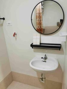 uma casa de banho com um lavatório e um espelho em JustAnn Escape Staycation em Manilla