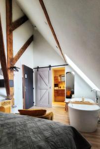 a attic bedroom with a bed and a bath tub at Dream Boutique Edam Bed & Coffee in Edam