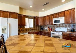 Playa El ParaísoにあるCasa Talebi El Dorado Ranch San Felipe WiFiのキッチン(木製キャビネット、大きな木製テーブル付) +23枚の写真