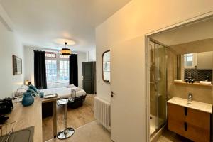 a bathroom with a bed and a sink and a mirror at Rive Droite - Studio Trouville in Trouville-sur-Mer