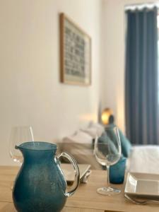 a blue vase sitting on a table with a wine glass at Rive Droite - Studio Trouville in Trouville-sur-Mer