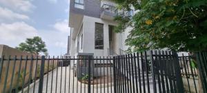 a black fence in front of a white house at Amal Suites in Accra