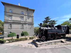 een trein die voor een gebouw te zien is bij Apartment Platana in Rijeka