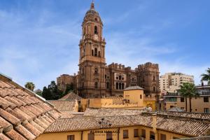 um edifício antigo com uma torre de relógio numa cidade em Cathedral Premium Suite Front View By AlohaMálaga em Málaga
