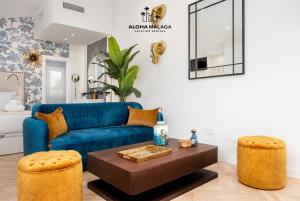 uma sala de estar com um sofá azul e uma mesa em Cathedral Premium Suite Front View By AlohaMálaga em Málaga