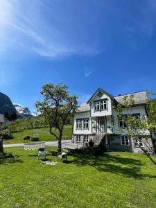 una gran casa blanca con un patio de césped en Monshaugen Home, en Sykkylven
