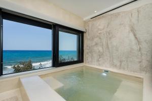 a swimming pool with a view of the ocean at Portara Seaside Luxury Suites in Naxos Chora