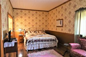 a bedroom with a bed and a chair at Mariposa Hotel Inn in Mariposa