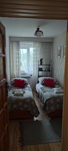 a bedroom with two beds and a window at Retrospekcja - Apartament w centrum in Zakopane