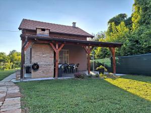 a small house with a pavilion in a yard at Kuća za odmor Sweet Home in Vukovar