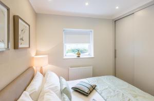 a bedroom with a bed and a window at High Street Kensington Apartment in London