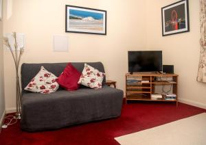 sala de estar con sofá gris con almohadas en Entire apt. quiet area near Leeds Castle Maidstone, en Harrietsham