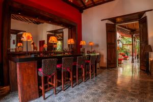 eine Bar in einem Zimmer mit roten Wänden und Stühlen in der Unterkunft Casa Bubu Guest House in Granada
