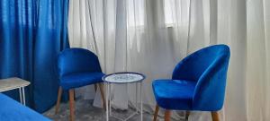 拉巴特的住宿－RABAT RESIDENCE - rooms & aparts，两个蓝色的椅子和一张桌子