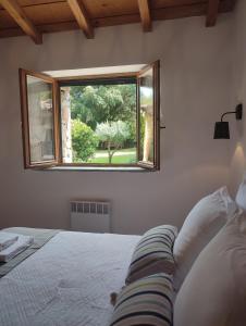 a bedroom with a bed and a window at Les Bergeries de Piazzagina in Piediquarciu
