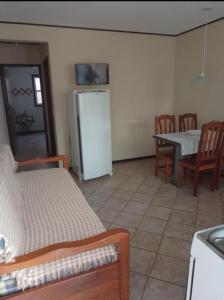 a living room with a table and a refrigerator at Residêncial Rosa in Florianópolis