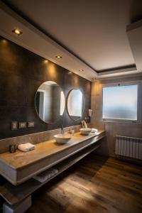 a bathroom with two sinks and two mirrors at Villas Del Malbec Lodges in Agrelo