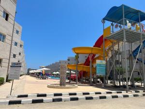 a playground with a slide next to a pool at Tahiti Bay in Marsa Matruh