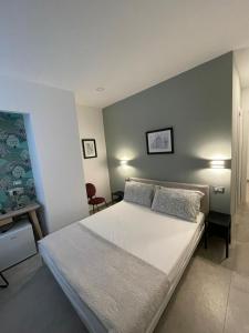 una camera da letto con un grande letto bianco con due cuscini di Domus Cervantes Apartment a Napoli