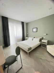una camera da letto con un letto e una sedia di Domus Cervantes Apartment a Napoli Altre 38 foto