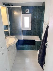 uma casa de banho com uma banheira, um lavatório e um WC. em superbe Loft lumineux à proximité des lacs em Riez