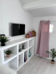 una sala de estar con TV en un estante blanco en superbe Loft lumineux à proximité des lacs en Riez