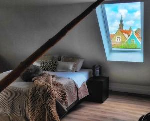 a bedroom with a bed and a large window at Dream Boutique Edam Coffee & Comfort in Edam