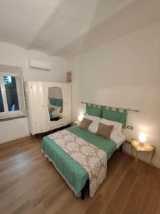 a bedroom with a large bed with a green blanket at Discover Donatello - Fiorenza in Florence