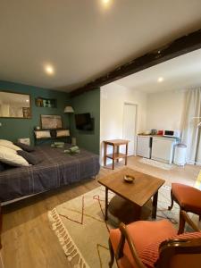 um quarto com uma cama, uma mesa e uma cozinha em La maison des rosiers au bord du Loir 